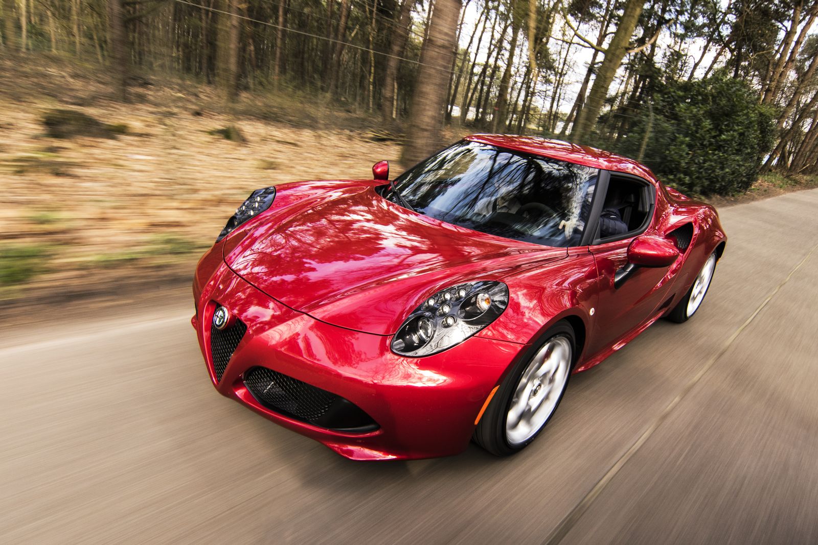 Red sport coupe driving on a road for the lease calculator page